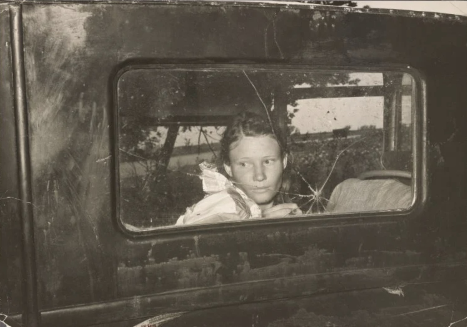 Migrant worker looking through back window of automobile near Prague, Oklahoma 